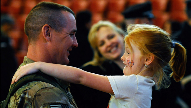 Sgt. 1st Class Paul Brady of the 182nd Infantry Massachusetts National Guard embraces his 6-year-old daughter, Regan, during a welcome home ceremony in Melrose, Massachusetts. The 182nd Infantry Regiment, one of the original units in the United States military, returned from a yearlong deployment in Afghanistan.