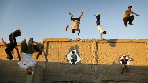 Palestinian youths practice their parkour skills in Khan Younis in southern Gaza. Parkour athletes run along a route, using obstacles to propel themselves.