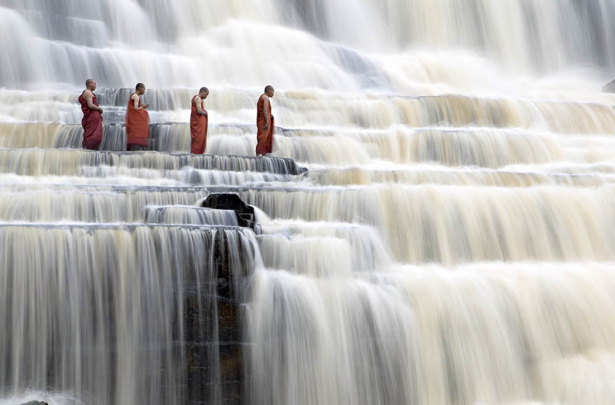 Meditating monks at Pongour Falls in Dalat, Vietnam.