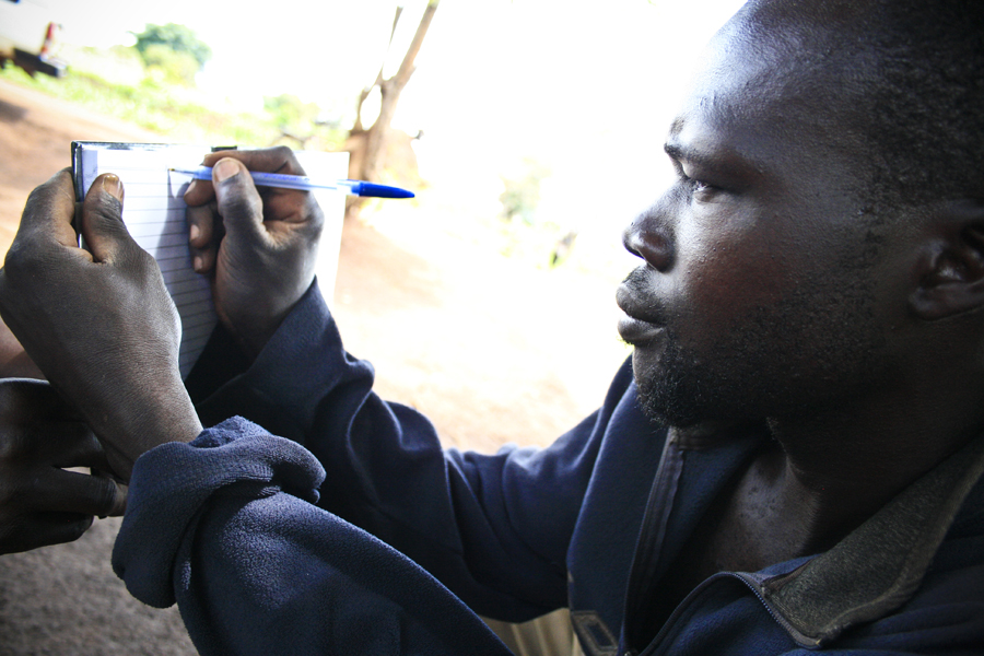 Ocan writes his name, something he learned to do in an Invisible Children Uganda adult literacy class.