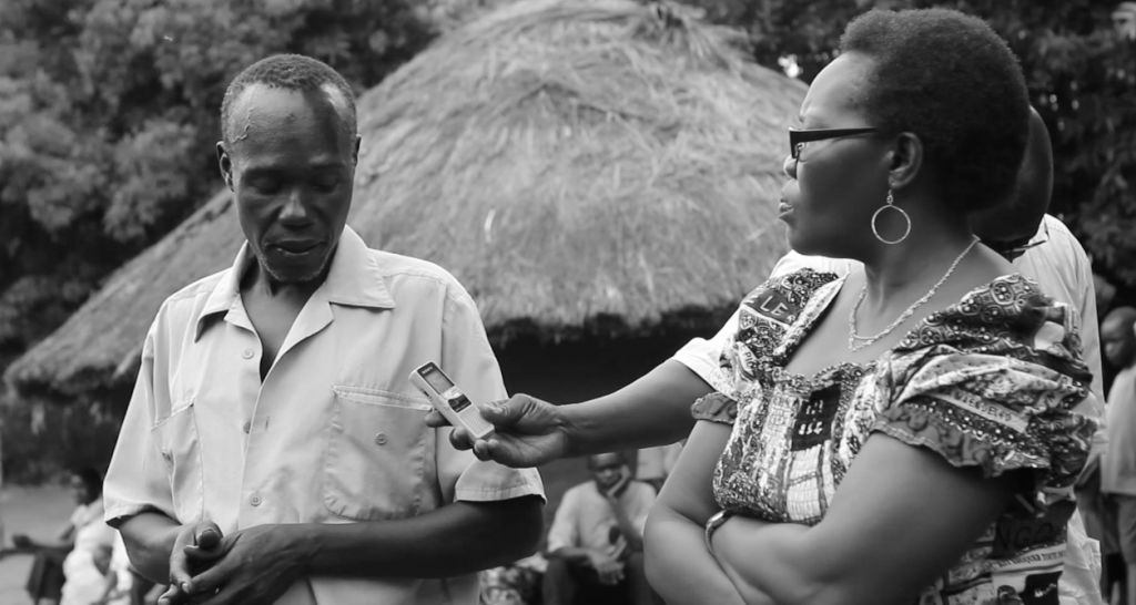 Invisible Children's co-founder and ambassador for victims, Jolly Grace Okot Andruville (pictured right), translates for a survivor of the Lukodi massacre as he shares his story.